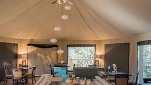 A tented room with a dining table, chairs, and a ceiling fan. - WYLDSTAY Smoky Mountains (Sevierville)