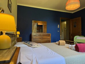 A hotel room with a bed, a wooden dresser, a mirror, and a hanging lamp. - Casale Ripabianca: 27 beds, private pool   (Ripabianca)