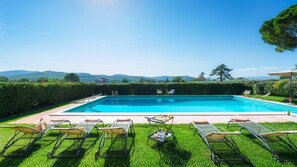 A rectangular swimming pool with a clear blue water, surrounded by a well-maintained lawn and metal sun loungers. - Casale Ripabianca: 27 beds, private pool   (Ripabianca)