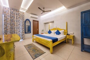 A bedroom with a bed, bedside table, nightstand, and a mirror.