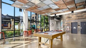 A billiards table in a spacious indoor area with large windows, a pool table, and a modern ceiling design. - The Urban Loft Free Parking 9 Minutes To OSU (Columbus)