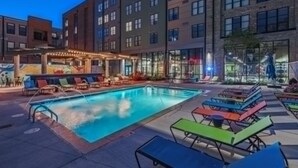 A pool area with lounge chairs and a bar area with outdoor seating. - The Urban Loft Free Parking 9 Minutes To OSU (Columbus)