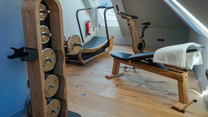 A home gym with wooden equipment, a treadmill, and a rowing machine. - Conlon House Lower East Side (Munich)