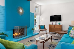 A living room with a fireplace, a sofa, a television, and a cabinet.