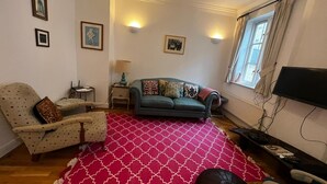 Un soggiorno con divano, poltrona e tappeto decorato.