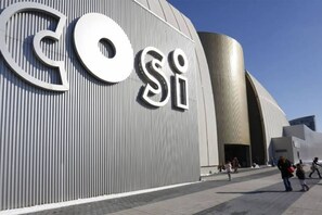 Un bâtiment moderne doté d’une grande façade métallique et d’un logo bien visible.