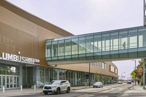 Un bâtiment moderne doté d’une grande entrée en verre et d’une enseigne indiquant « CENTRE DE CONGRÈS UMBUS ».