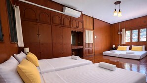 Ein Hotelzimmer mit zwei Betten, Holzwandverkleidung, einem Schreibtisch und einem großen Kleiderschrank.