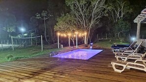A wooden deck with a swimming pool and lounge chairs. - Country House with Waterfall and Pool - Maciambu Waterfall - Country House (Enseada de Brito)