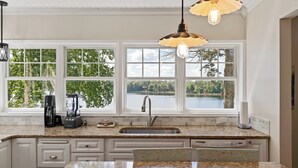 A kitchen with a large window, a sink, and a coffee maker. - Northbound Stays | Fish, Swim & Bike (Garrison)