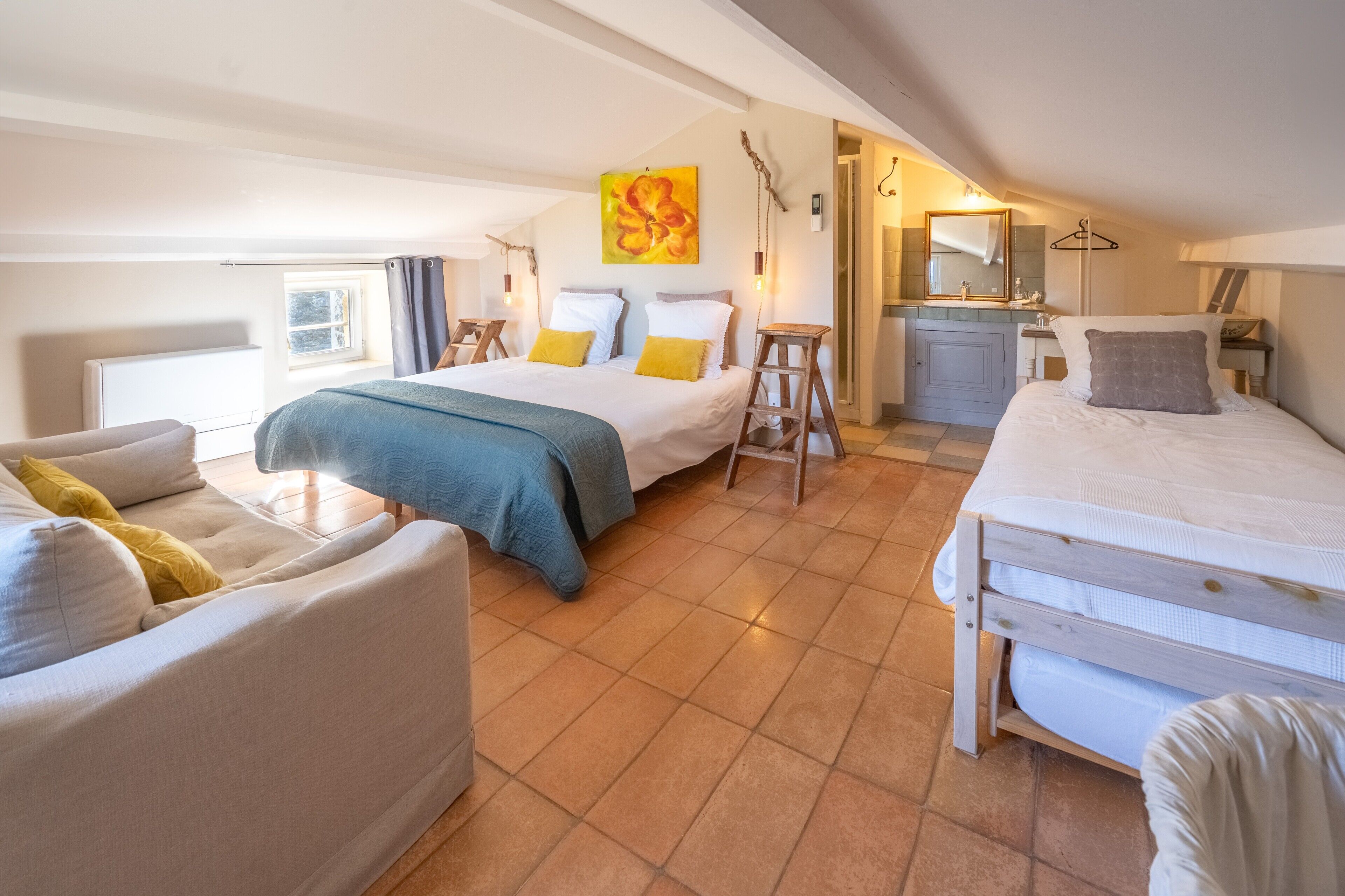 Une chambre à coucher comprenant un lit, un canapé, un bureau et une salle de bain.