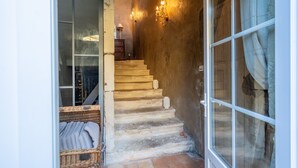 A staircase leading to a room with a wicker basket and a lamp on a dresser. - Gîte 'Les Aiguières en Provence' with Private Terrace, Private Garden and Wi-Fi (Suze-la-Rousse)