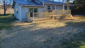 A single-story house with a covered porch, a front door, and a small front yard. - House of Friendship, Connect in a Relaxing Getaway near Red River Gorge (Wellington)