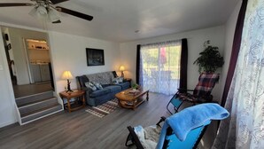 A living room with a sofa, coffee table, and chairs. There is a staircase leading to an upper floor. - House of Friendship, Connect in a Relaxing Getaway near Red River Gorge (Wellington)