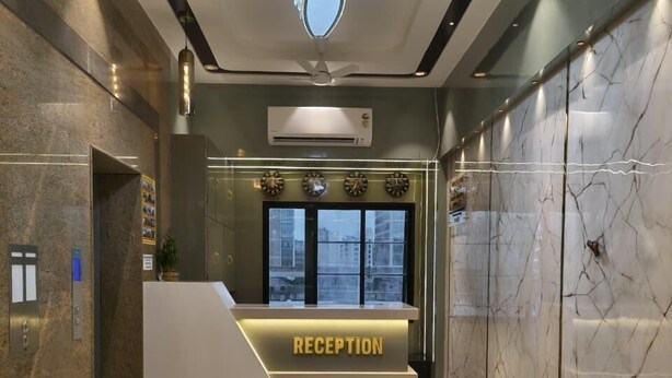 A reception desk with a 'RECEPTION' sign, a ceiling light fixture, and a wall-mounted air conditioner.