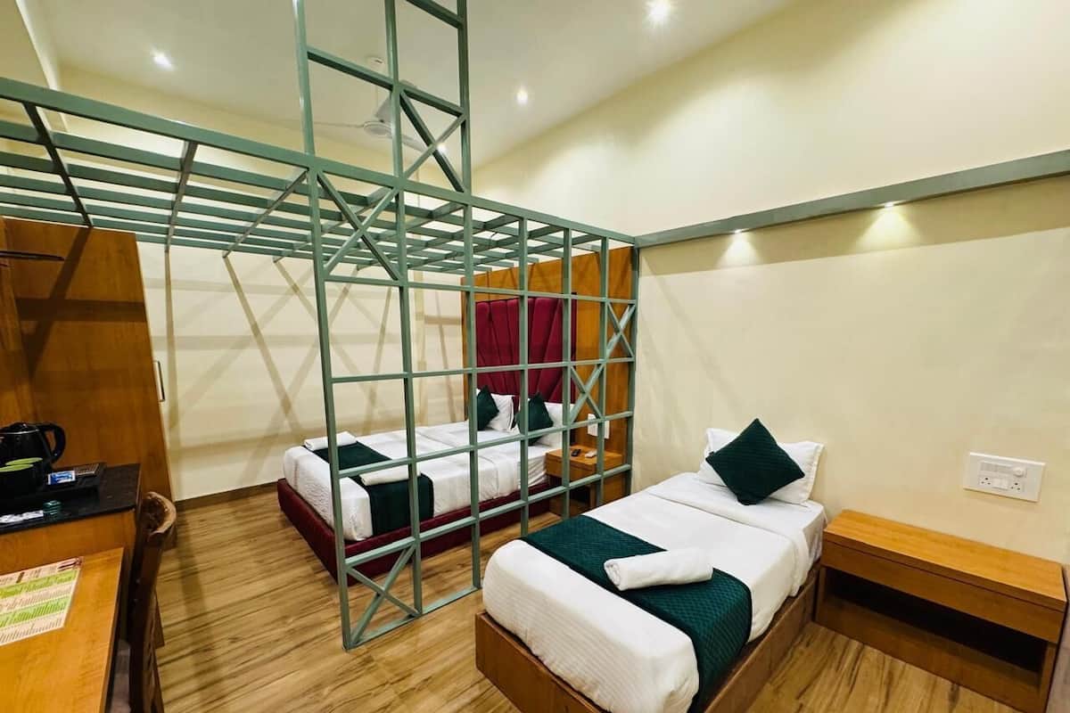 Een kamer met twee bedden, een bureau en een houten vloer.