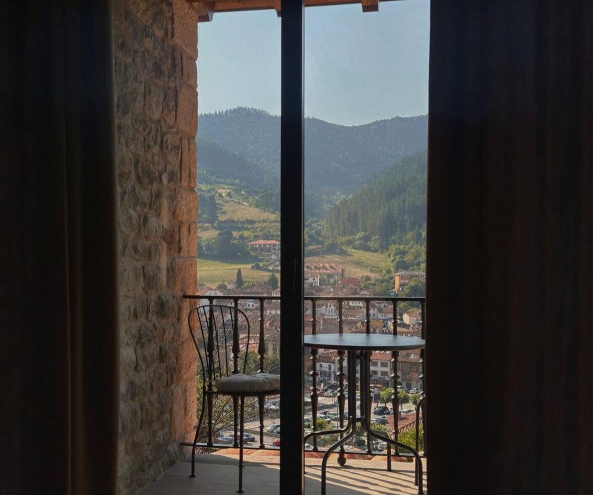 Un balcón con vista a un pueblo y colinas.