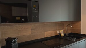 A modern kitchen with a built-in microwave, a sink, and a coffee maker. - El Balcón de Potes  (Potes)