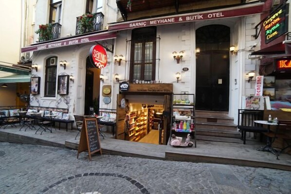A street view of a building with a sign for 'Sarnic Meyhan & Butik Otel' and a visible entrance.