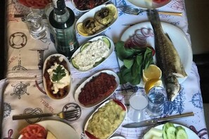 A table with various dishes, including fish, vegetables, and sauces.