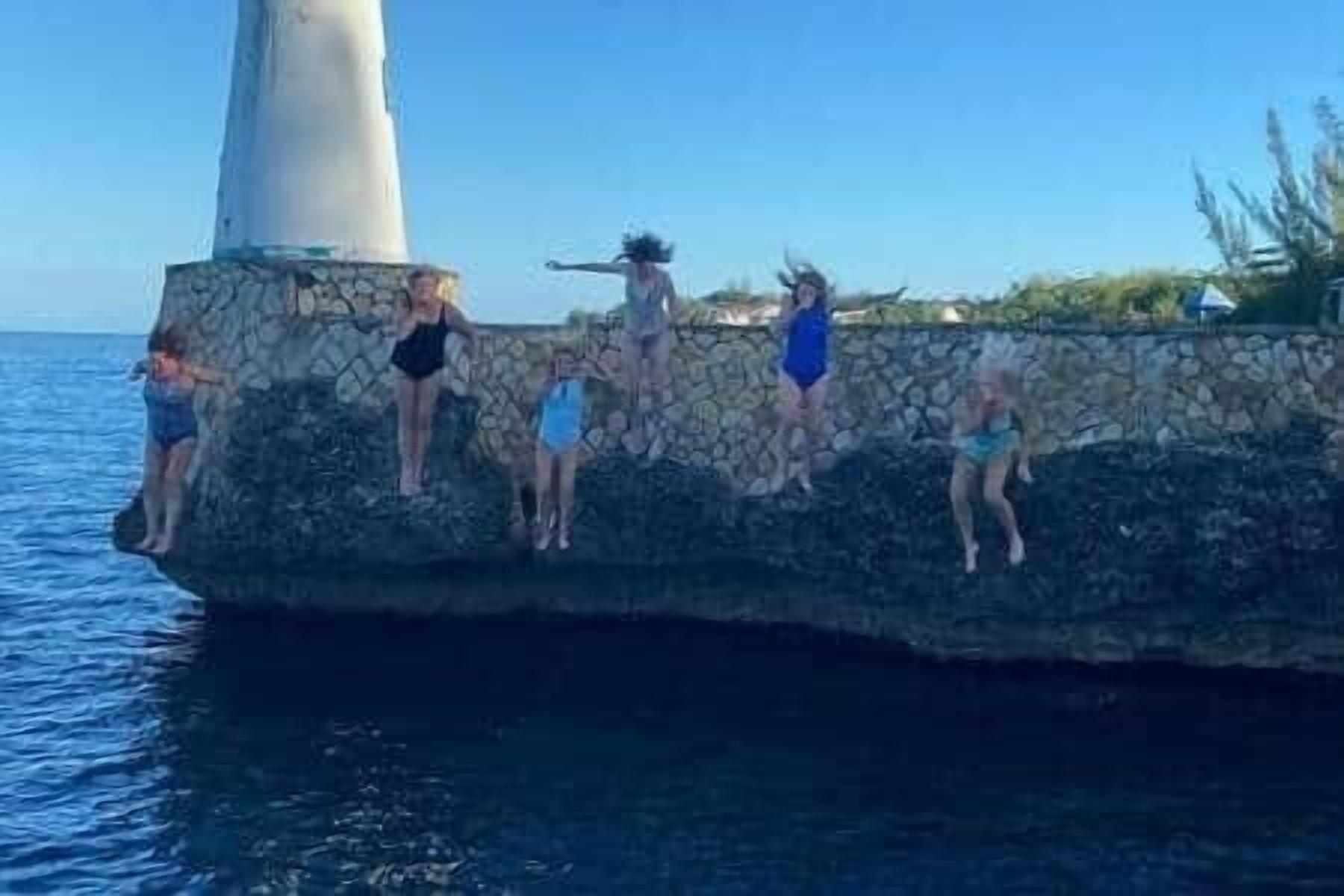 A group of people on a stone pier by the sea.