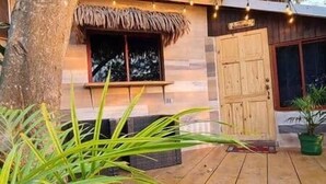 Una construcción de madera con techo de paja, una ventana y una puerta.