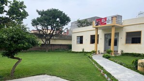 A building with a flat roof, a paved entrance, and a well-maintained lawn.