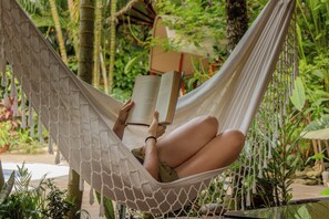 A hammock with a person reading a book, surrounded by greenery. - Villa Lu Amazon Lodge (Tarapoto)
