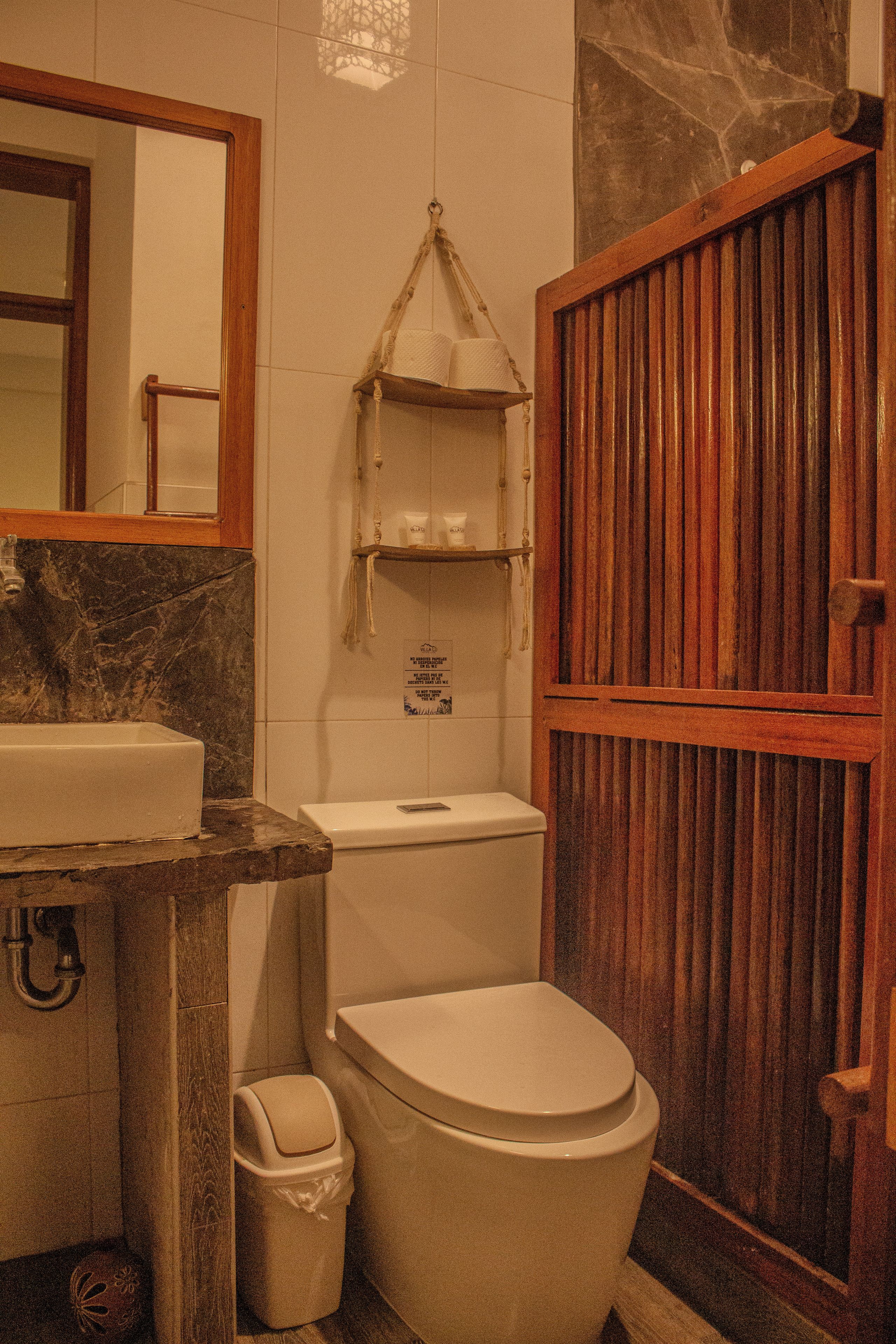 Ein Badezimmer mit Holztür, Marmorwaschbecken und Toilette.