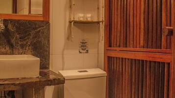Ein Badezimmer mit Holztür, Marmorwaschbecken und Toilette.