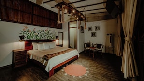 A bedroom with a wooden bed, a nightstand, a desk, and a chair. - Villa Lu Amazon Lodge (Tarapoto)