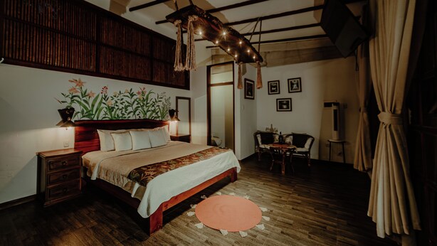 Un dormitorio con una cama de madera, una mesita de noche, un escritorio y una silla.