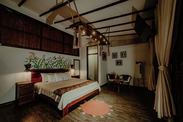 A bedroom with a wooden bed, a nightstand, a desk, and a chair. - Villa Lu Amazon Lodge (Tarapoto)