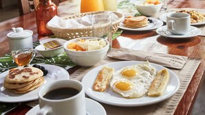 A breakfast table with plates of food, a coffee cup, and a pitcher of orange juice. - Villa Lu Amazon Lodge (Tarapoto)