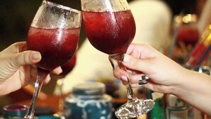 Two people toasting with wine glasses filled with a red beverage. - Villa Lu Amazon Lodge (Tarapoto)