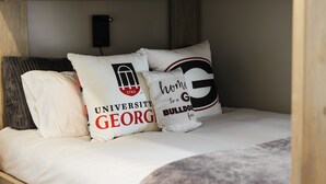 A bunk bed with pillows featuring university and bulldog logos.