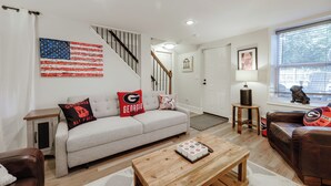 A living room with a sofa, coffee table, and a staircase.
