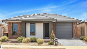 A modern two-story house with a garage, a brick facade, and a well-maintained front yard with shrubs. - 3BR Home Near Werribee Plaza w/ Free Parking + Free Wifi (Mambourin)