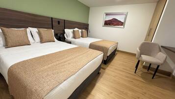 A hotel room with two beds, a chair, and a painting on the wall.