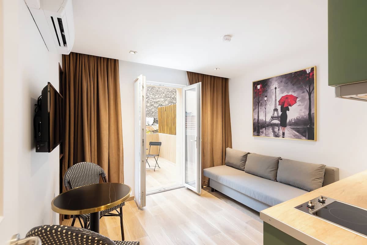 Ein modernes Wohnzimmer mit einer Couch, einem Esstisch und einem Fernseher.