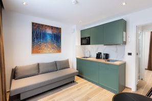 Les Suites Parisiennes | Living area | 32-inch flat-screen TV with digital channels