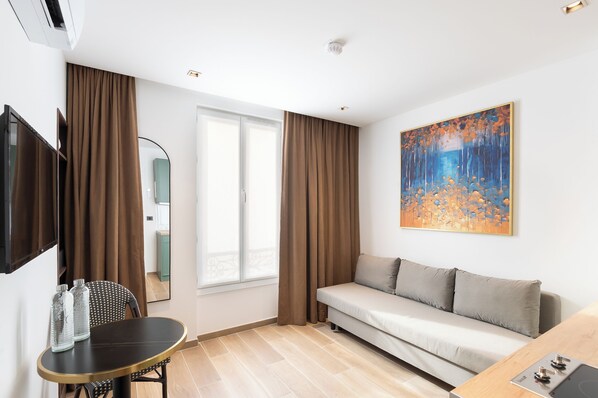 Les Suites Parisiennes | Living area | 32-inch flat-screen TV with digital channels