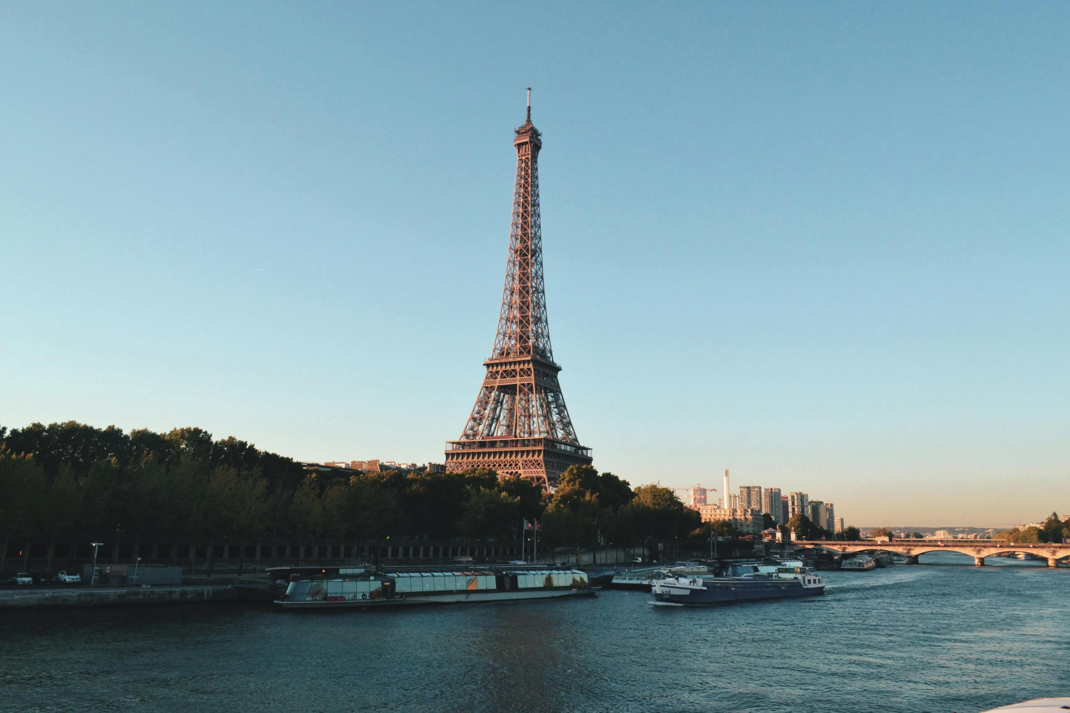 The Eiffel Tower with a river and bridges in the foreground.