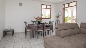 Een zithoek met een tafel en stoelen, een bank en een bijzettafeltje met een decoratief object.
