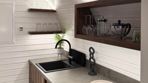 A modern kitchen with a built-in sink, wooden cabinets, and a countertop. - Iglu – Chestnut (Frensdorf)