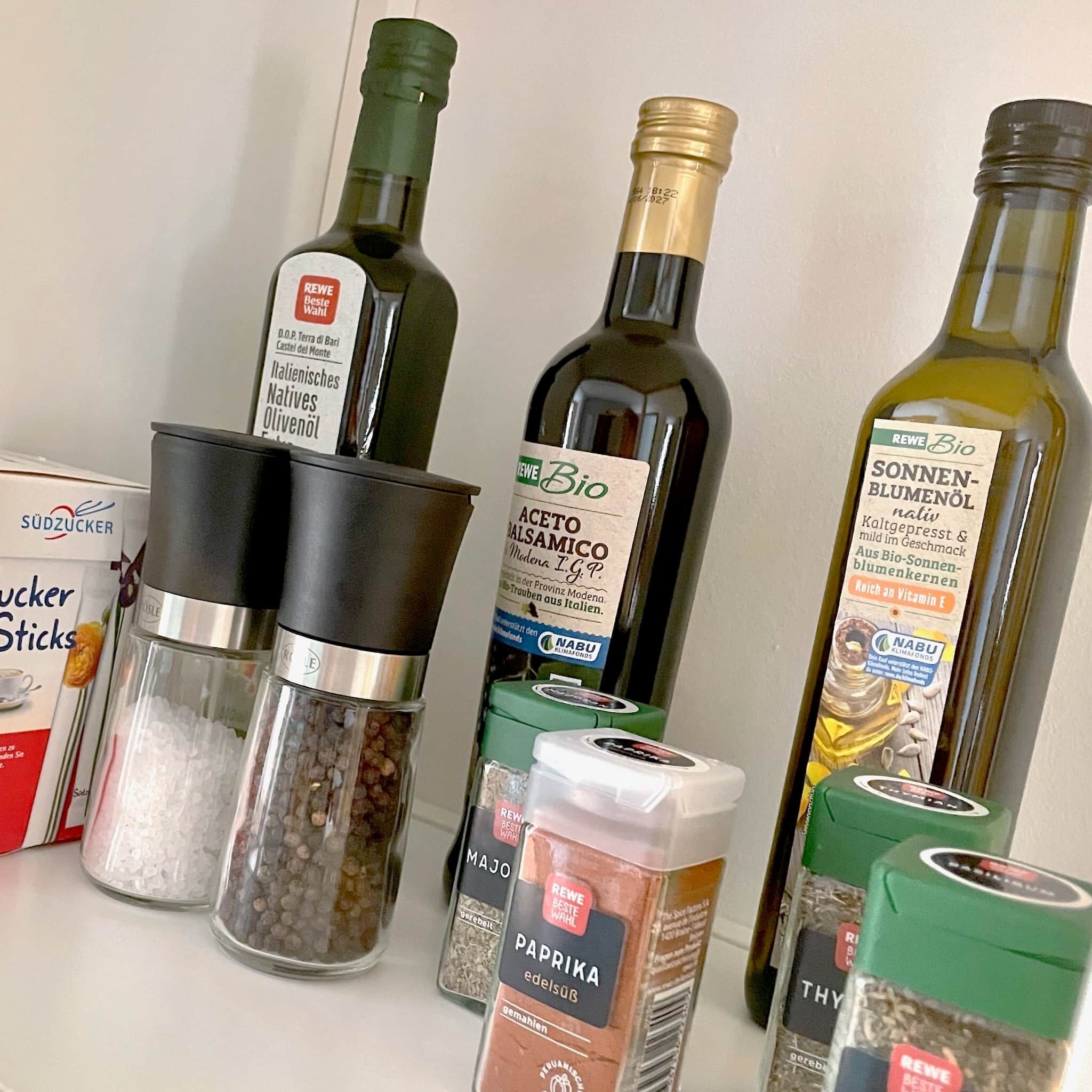 Various kitchen items including bottles of olive oil, salt shakers, and pepper shakers.