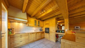 Een ruime keuken met houten kastjes, een betegelde spatwand en een groot eiland.