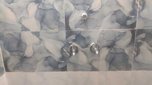 A bathroom with marble tiles and two chrome faucets. - Saraswat Niwas (Udaipur)