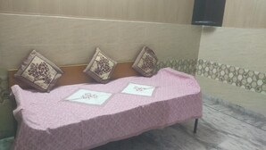 A bench with a pink cover and decorative pillows. - Saraswat Niwas (Udaipur)