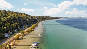 Uma área costeira com uma fileira de casas ao longo da praia, cais e águas turquesa cristalinas.